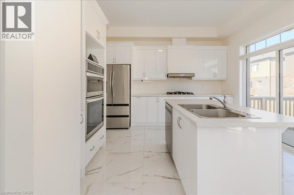 Kitchen featuring white cabinets, a kitchen island with sink, stainless steel appliances, light marble finish floors, and light countertops - 35 Hitchman Street, Paris, ON - Indoor Photo Showing Kitchen With Double Sink With Upgraded Kitchen