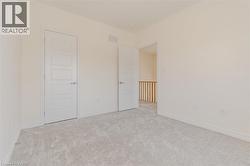 Unfurnished bedroom featuring light colored carpet and baseboards -