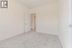 Spare room featuring light carpet and baseboards -