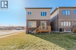 Back of house featuring brick siding, a yard, and a deck -