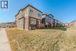 Rear view of house featuring brick siding and a yard -