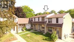View of front of home featuring roof with shingles, a front yard, and brick siding -