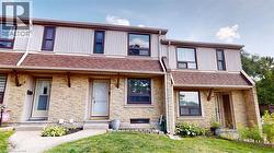 View of front of house with stone siding, a shingled roof, a porch, and a front lawn -