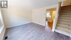 Unfurnished room with light wood finished floors and stairs -