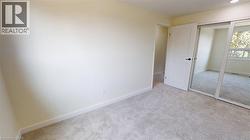 Unfurnished bedroom with light carpet and a closet -