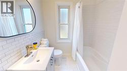 Full bath with healthy amount of natural light, shower / bath combination with curtain, vanity, and backsplash -