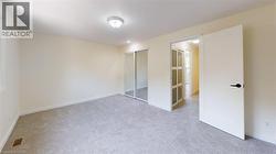 Unfurnished bedroom with light colored carpet and a closet -