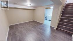 Finished basement with wood finished floors and stairway -
