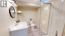 Bathroom with vanity, a shower stall, and light wood-style floors -