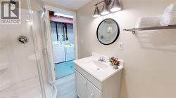 Full bath featuring vanity, separate washer and dryer, and a shower stall -
