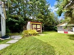 Storage shed and screened-in gazebo in backyard. -