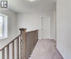 Corridor featuring carpet floors and an upstairs landing -
