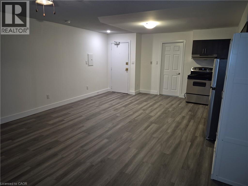 Unfurnished dining area featuring dark wood-style flooring - 27 Bridge Street Unit# 107, Brantford, ON - Indoor
