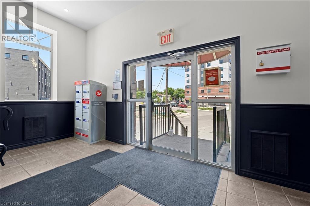 Community lobby with a wainscoted wall - 27 Bridge Street Unit# 107, Brantford, ON - Indoor