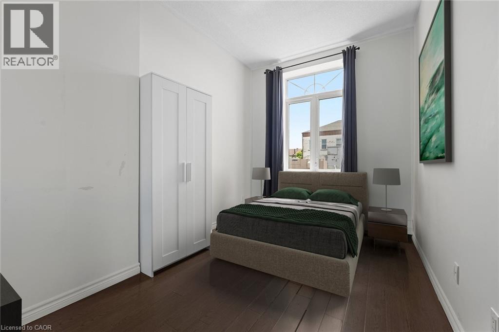 Bedroom featuring baseboards and dark wood-style floors - 27 Bridge Street Unit# 305, Brantford, ON - Indoor Photo Showing Bedroom