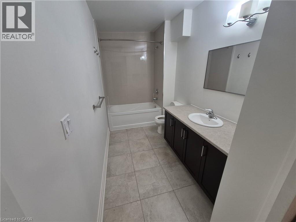 Full bathroom with shower / tub combination, vanity, and light tile patterned floors - 27 Bridge Street Unit# 305, Brantford, ON - Indoor Photo Showing Bathroom
