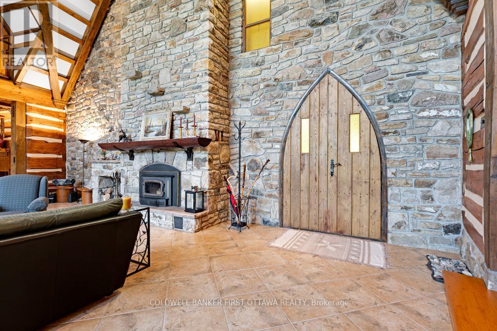 Living room stone wall - 2499 Bathurst Concession 2 Road, Tay Valley, ON - Indoor Photo Showing Other Room With Fireplace