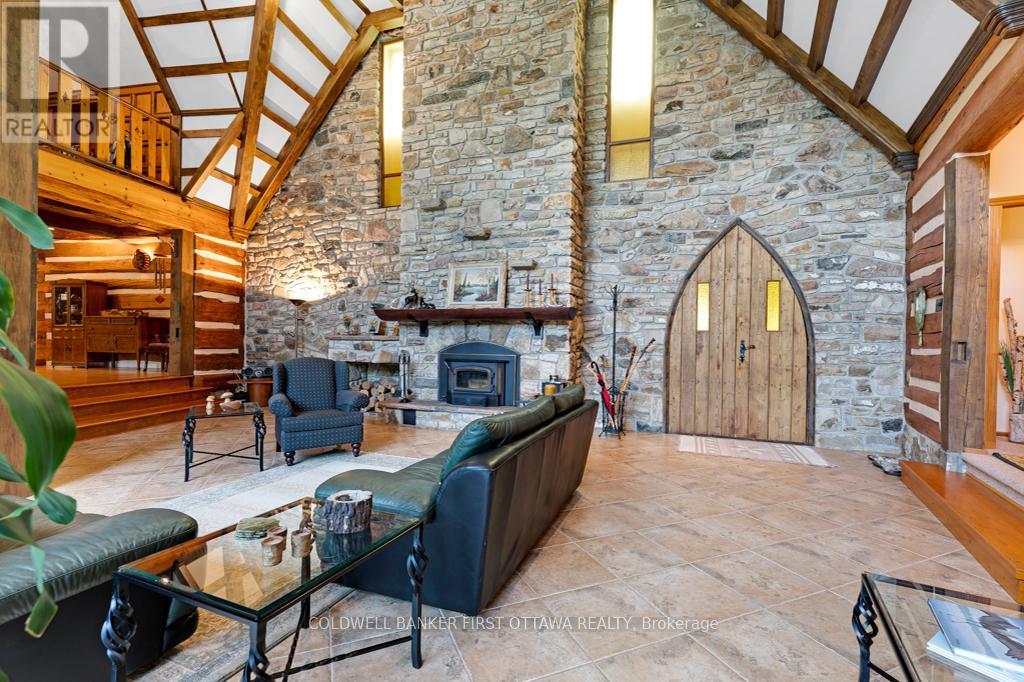 Stone fireplace with wood-stove insert - 2499 Bathurst Concession 2 Road, Tay Valley, ON - Indoor With Fireplace