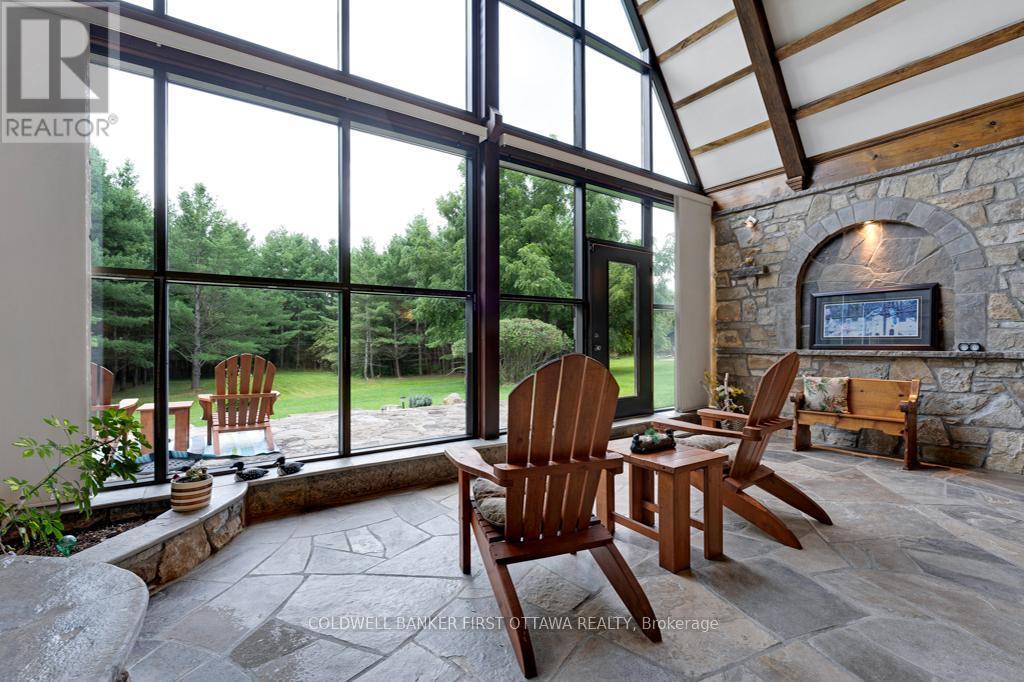 Solarium wall of windows - 2499 Bathurst Concession 2 Road, Tay Valley, ON - Indoor With Fireplace