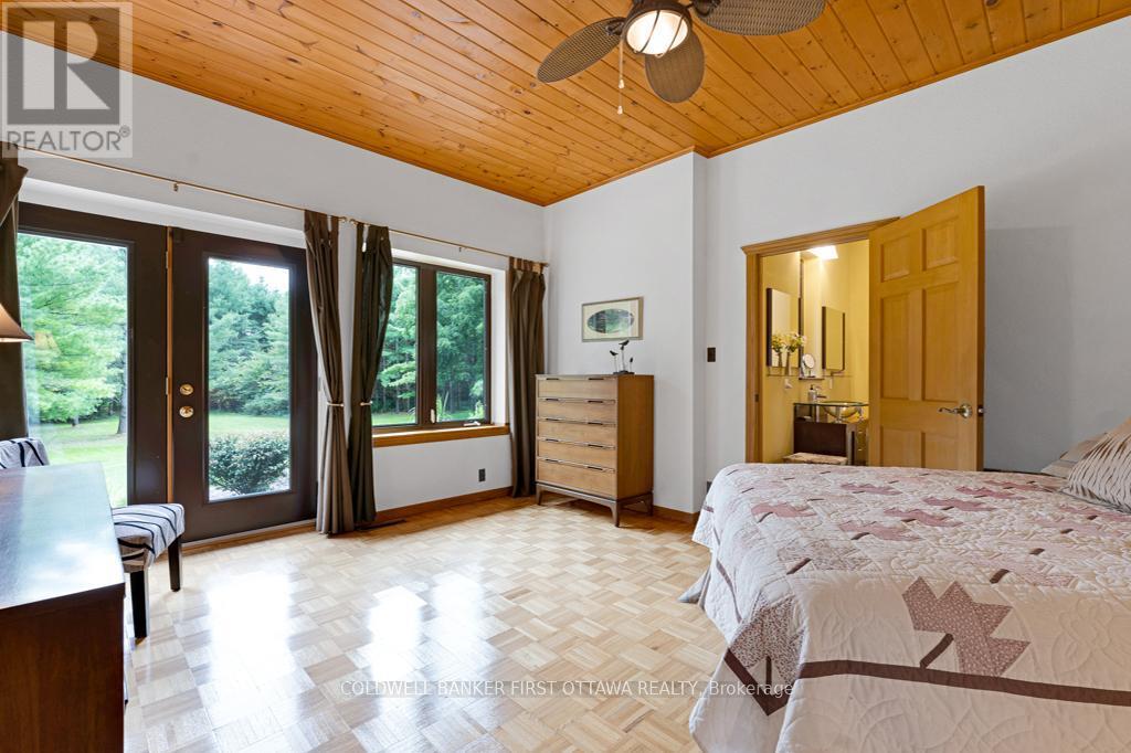 Main floor 2nd bedrm has ensuite & doors to patio - 2499 Bathurst Concession 2 Road, Tay Valley, ON - Indoor Photo Showing Bedroom