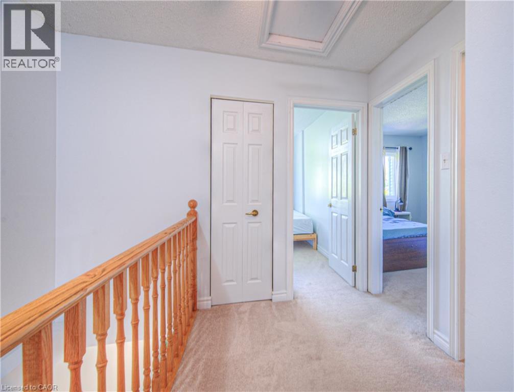 Corridor with light colored carpet, a textured ceiling, attic access, and an upstairs landing - 310 Christopher Drive Unit# 15, Cambridge, ON - Indoor Photo Showing Other Room