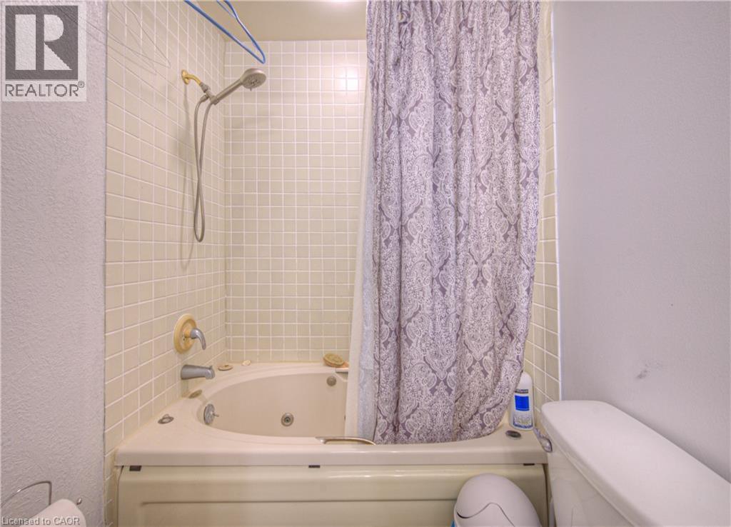 Bathroom with shower / bathtub combination with curtain and a textured wall - 310 Christopher Drive Unit# 15, Cambridge, ON - Indoor Photo Showing Bathroom