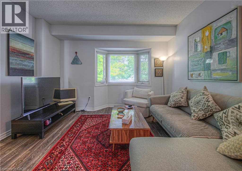 Living room featuring wood finished floors and a textured ceiling - 310 Christopher Drive Unit# 15, Cambridge, ON - Indoor Photo Showing Living Room