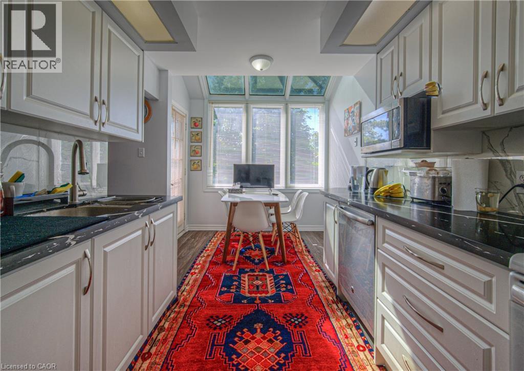 Kitchen featuring dark wood-type flooring, dark stone countertops, appliances, white cabinets - 310 Christopher Drive Unit# 15, Cambridge, ON - Indoor Photo Showing Kitchen