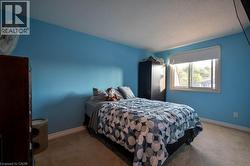 Carpeted bedroom featuring baseboards and a textured ceiling -