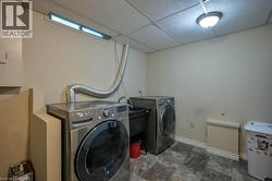 Washroom featuring washer and clothes dryer and stone finish flooring -