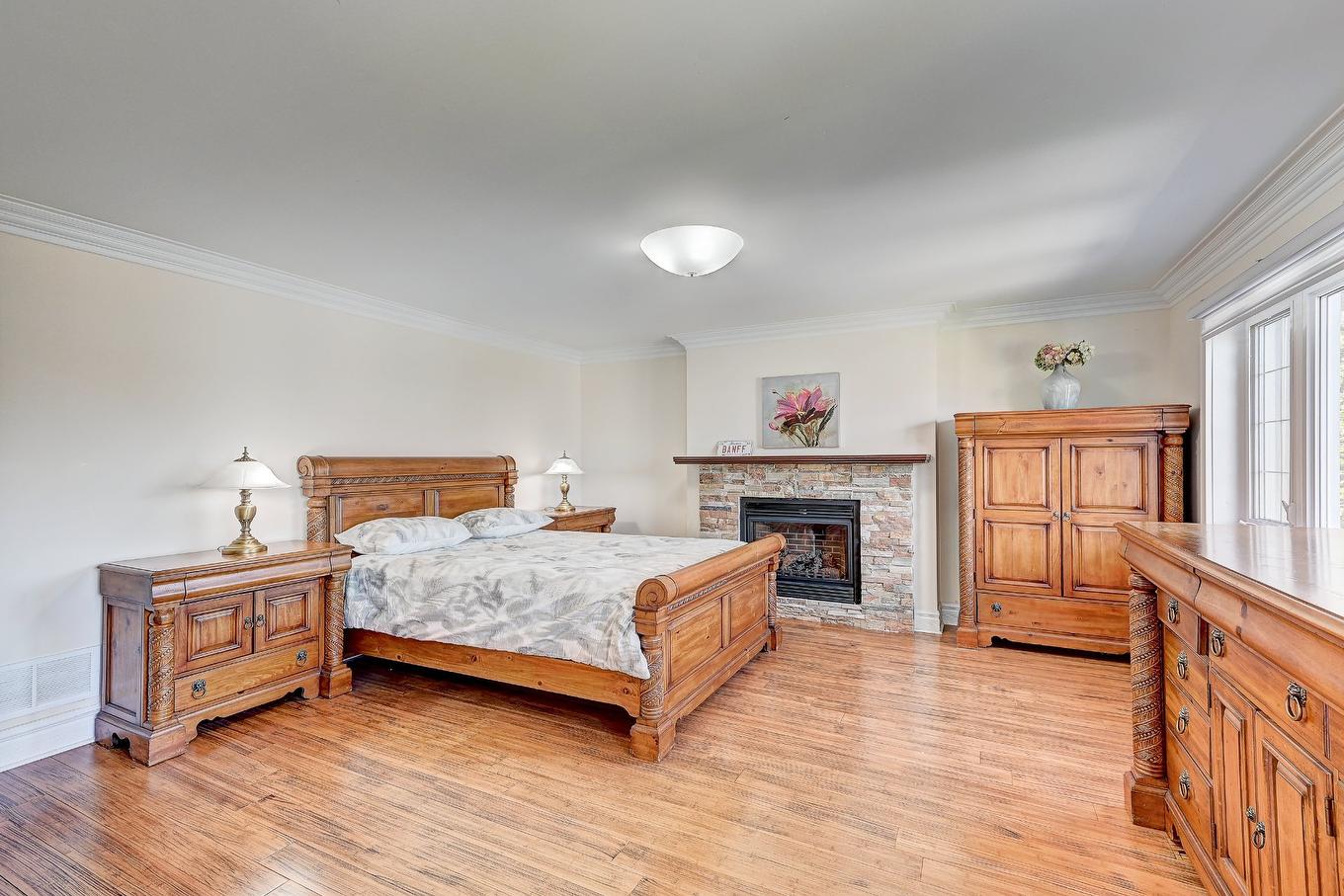 Chambre à coucher - 136 Rue Jean-De Ronceray, Carignan, QC - Indoor Photo Showing Bedroom With Fireplace