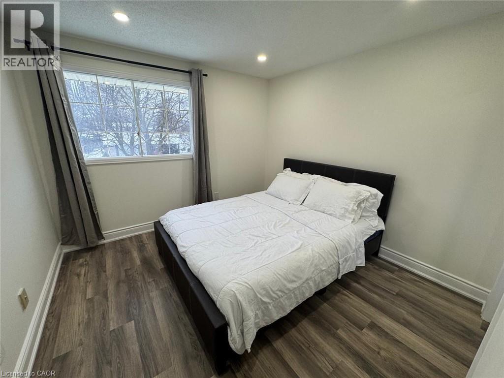 Bedroom featuring dark wood-type flooring, recessed lighting, and a textured ceiling - 389 Dunvegan Drive, Waterloo, ON - Indoor Photo Showing Bedroom