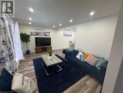 Living room with wood finished floors and recessed lighting -