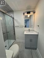Bathroom featuring vanity, a marble finish shower, light marble finish flooring, and a textured ceiling -