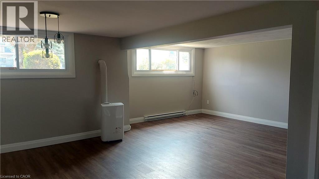 Basement with dark wood finished floors and a baseboard heating unit - 106 Chandler Drive Unit# 1, Kitchener, ON - Indoor Photo Showing Other Room