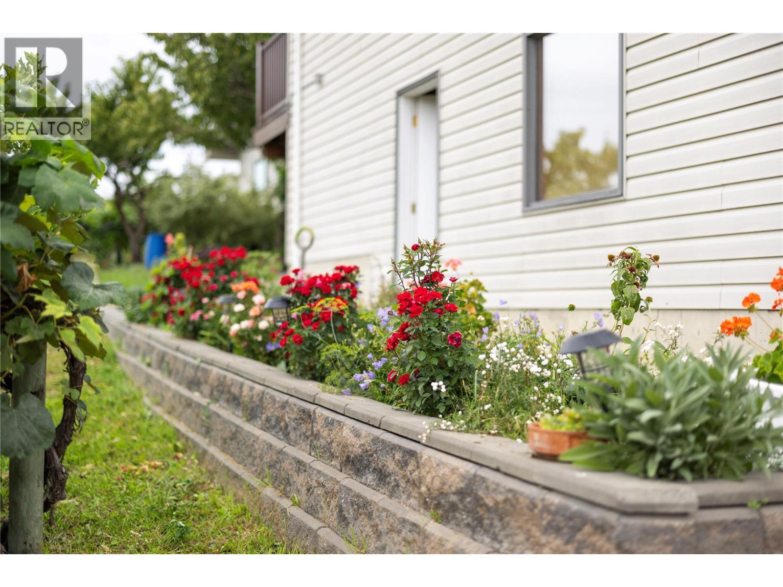 Roses along the house - 10108 Venables Drive, Coldstream, BC - Outdoor With Exterior