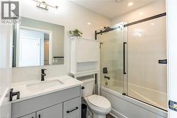 Bathroom with enclosed tub / shower combo, vanity, and recessed lighting -