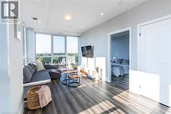 Living room with healthy amount of natural light, expansive windows, wood finished floors, and recessed lighting -