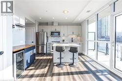 Kitchen with backsplash, beverage cooler, stainless steel appliances, a kitchen island, and a breakfast bar area -