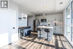 Kitchen with a breakfast bar area, backsplash, light countertops, stainless steel appliances, and a kitchen island -