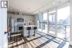 Kitchen with a wall of windows, decorative backsplash, stainless steel appliances, a kitchen island, and a kitchen bar -