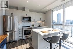 Kitchen featuring appliances with stainless steel finishes, tasteful backsplash, a city view, recessed lighting, and a breakfast bar -