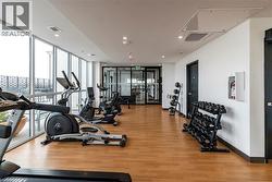 Workout area featuring floor to ceiling windows, light wood finished floors, and recessed lighting -