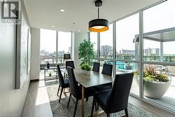 Dining area with a wall of windows, a view of city, light wood-style flooring, and recessed lighting -
