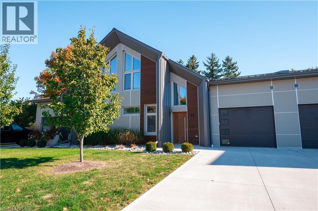 View of front of house with a front lawn, driveway, a garage, and stucco siding - 92 Elgin Street, Embro, ON - Outdoor