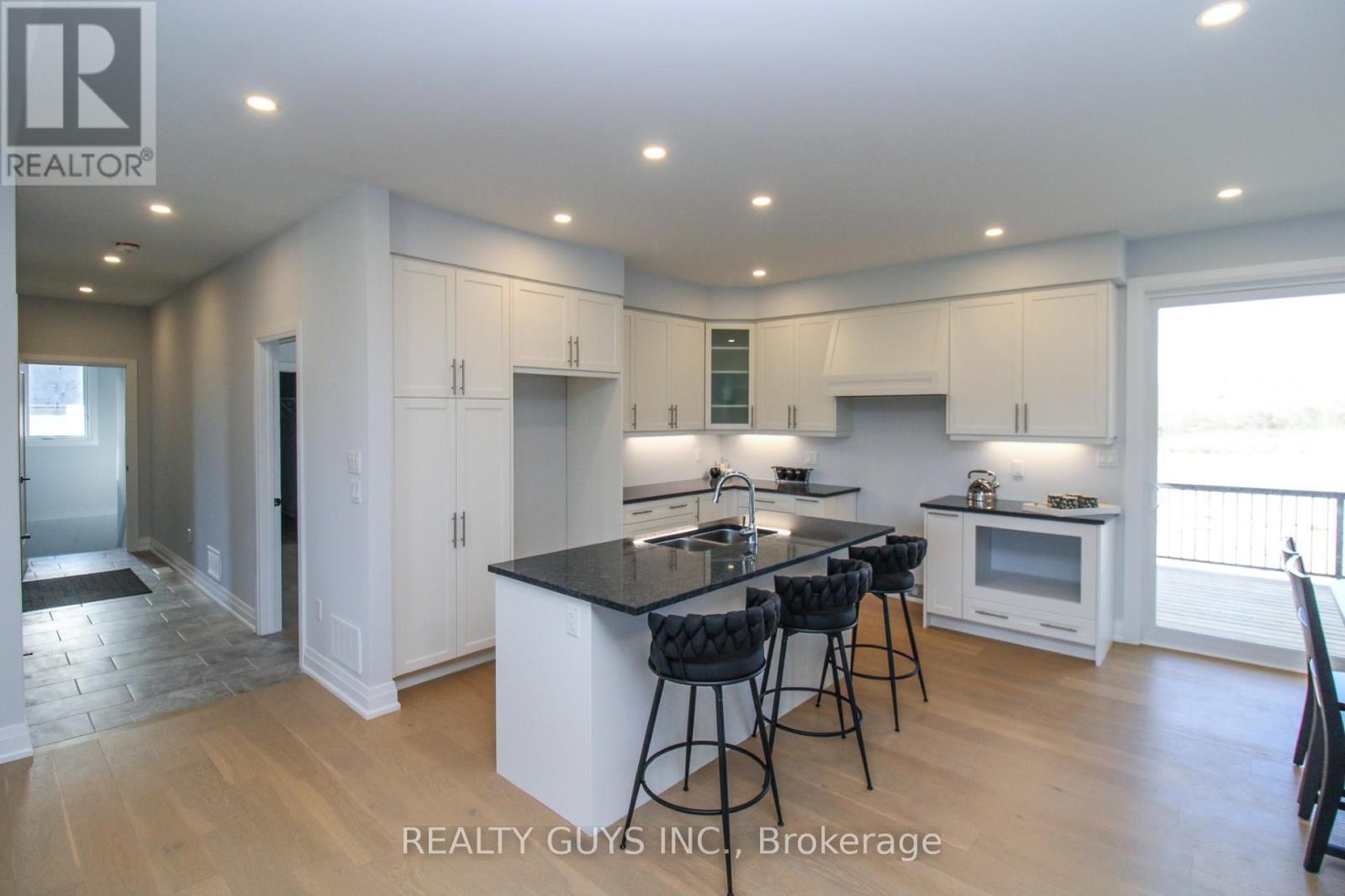 KITCHEN----HALLWAY TO PRIMARY BEDROOM, LAUNDRY.... - 2418 Gwendolyn Court, Cavan Monaghan (Cavan Twp), ON - Indoor Photo Showing Kitchen With Upgraded Kitchen