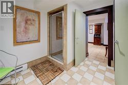 Hallway with baseboard heating and light tile patterned floors -