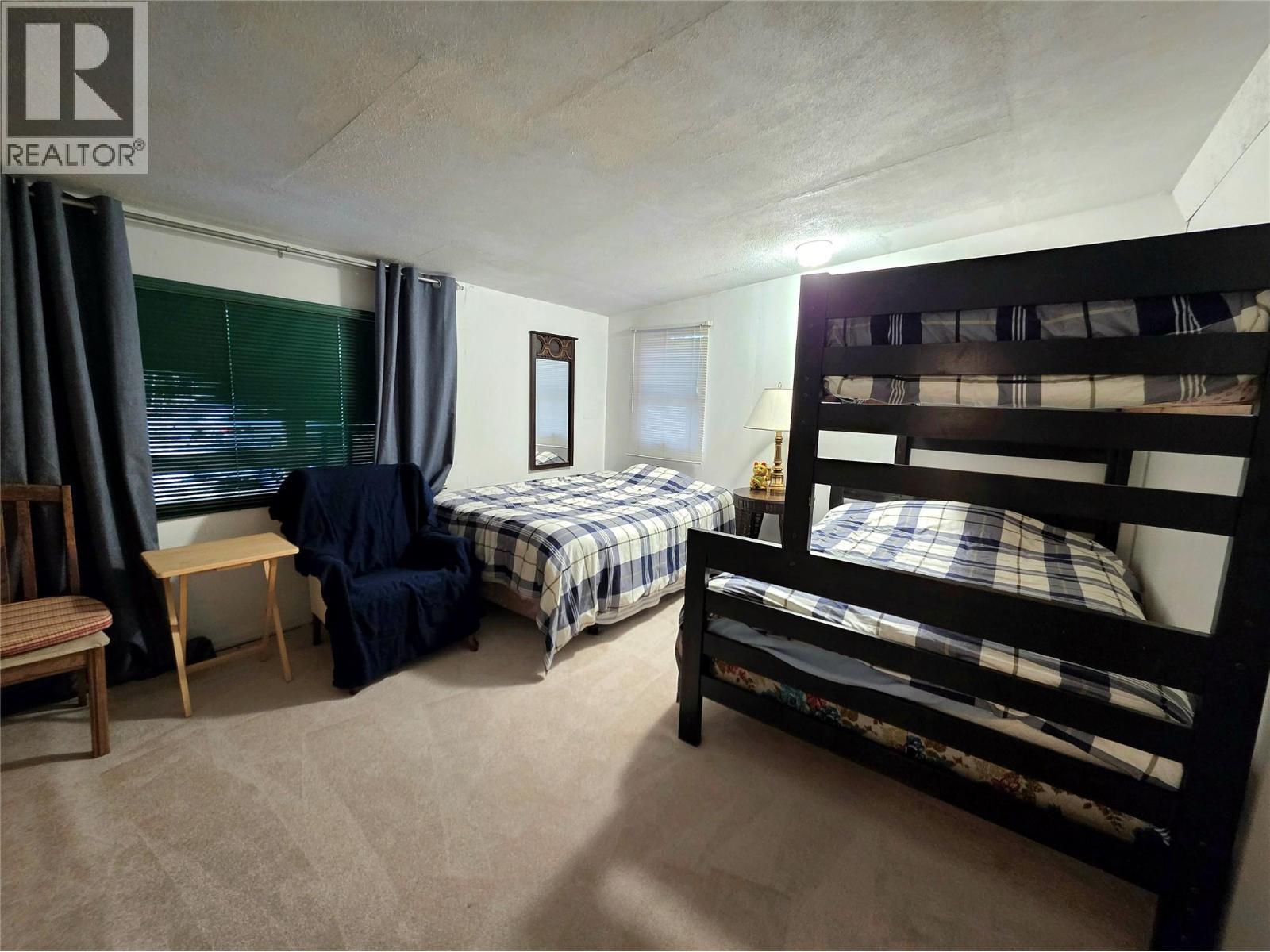 Second bedroom with 1 queen bed and a queen and double bunk beds - 6453 Pinaus Lake Road Lot# 6297, Falkland, BC - Indoor Photo Showing Bedroom