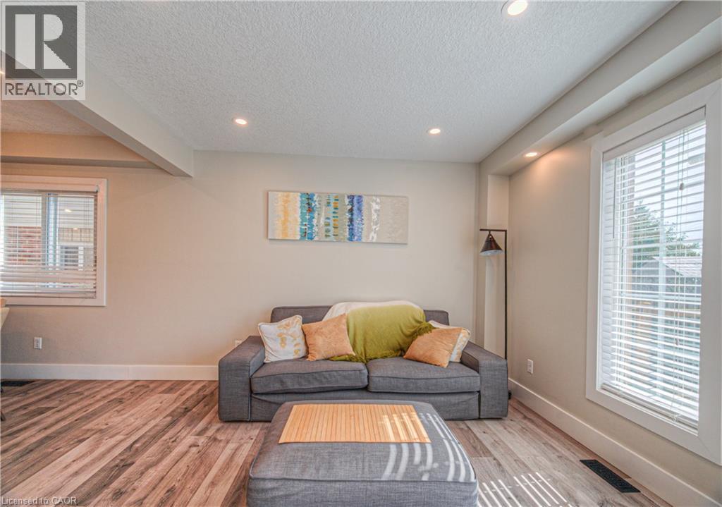 Living room featuring a textured ceiling, wood finished floors, and recessed lighting - 220 Sienna Crescent, Kitchener, ON - Indoor