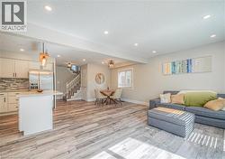 Living area featuring a textured ceiling, stairway, recessed lighting, and light wood-style flooring -